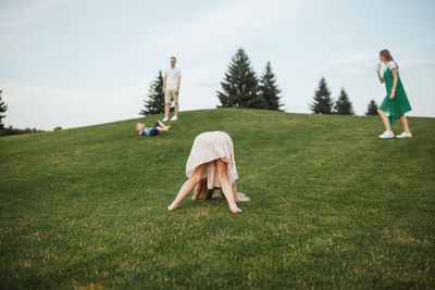 Girl playing on grass against sky