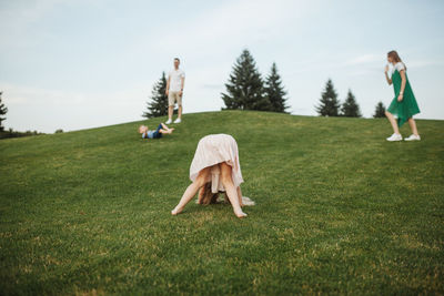 Playful family on field against sky