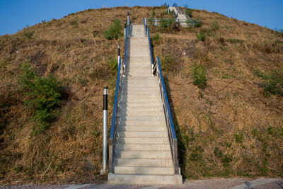 Staircase leading towards mountain against sky