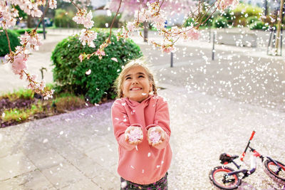 Cute girl playing amidst flower petals