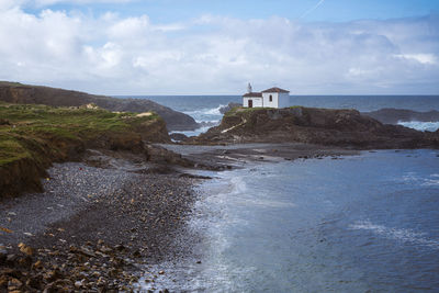 Atlantic ocean. galicia, spain. scenic view of white chapel on top of a rock.virxe do porto ermitage