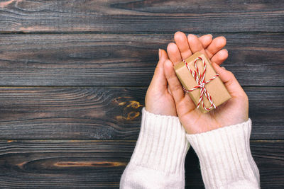 Close-up of woman holding gift on table