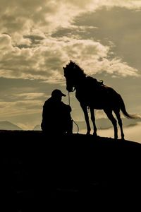 Silhouette of horse against sky during sunset