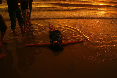 High angle view of woman lying at beach during sunset