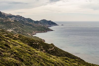 Scenic view of sea and mountains against sky