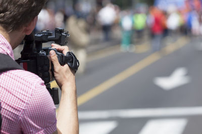 Rear view of man photographing on street