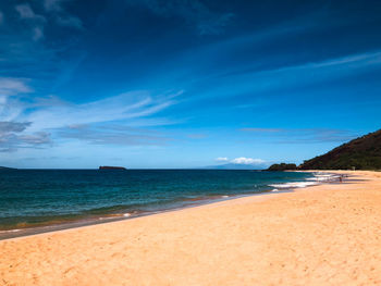 Scenic view of beach against blue sky