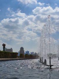 Fountain in city against sky