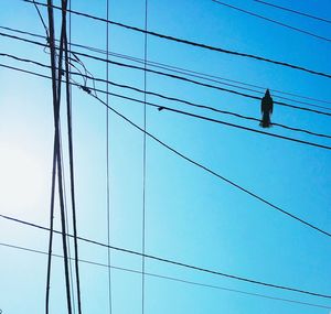 Low angle view of electricity pylon against blue sky