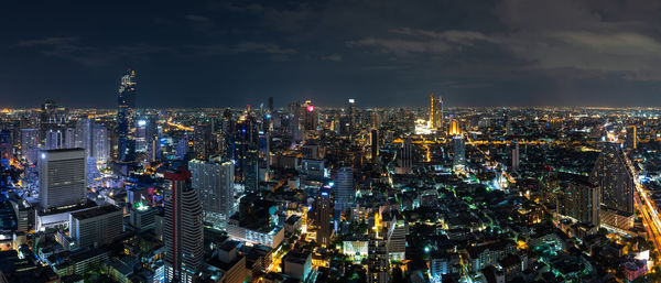 High angle view of illuminated city against sky at night