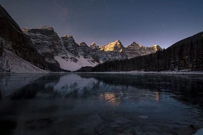 Moraine lake at night under a starry sky