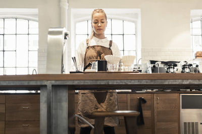 Female barista working at counter in coffee shop