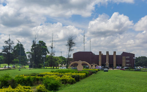 Built structure on field by trees against sky