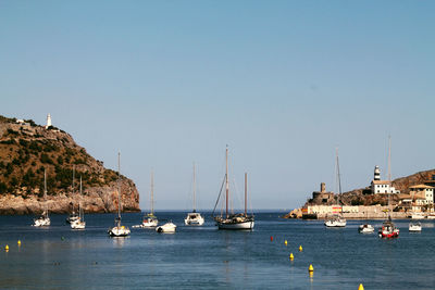 Boats sailing on sea against clear sky