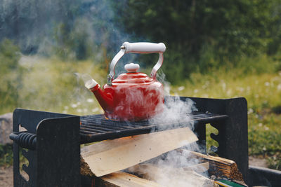 Heating up water in a red kettle while camping