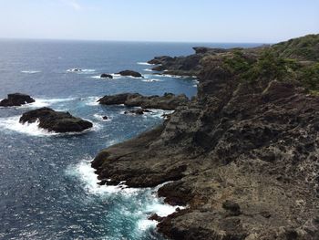 Rocks in sea against clear sky