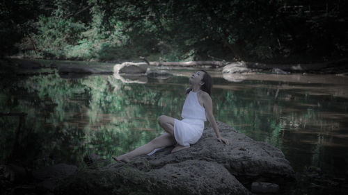 Woman sitting on rock in forest