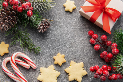 Christmas background with gingerbread cookies, gift boxe and fir branches on  concrete background. 