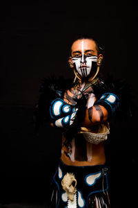 Portrait of man wearing mask against black background