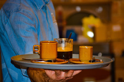 Close-up of hand holding beer glass on table