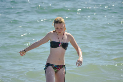 Full length of woman standing in sea