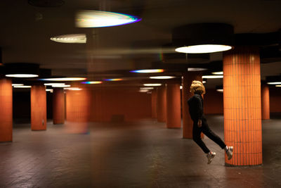 Woman jumping in illuminated garage