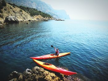 High angle view of man kayaking on sea against sky