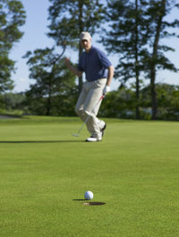 Low section of man playing golf on field