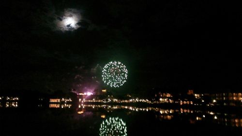 Reflection of illuminated lights in pond at night