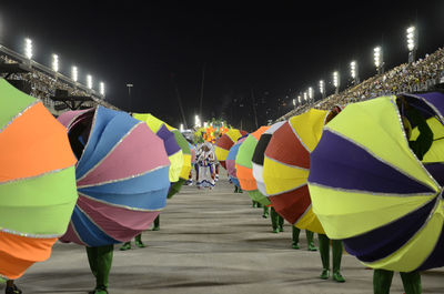 People on multi colored umbrellas against sky at night