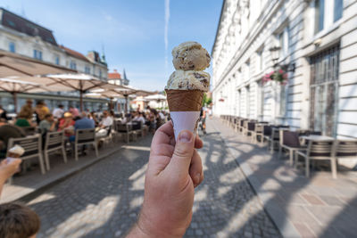 Man holding ice cream in city