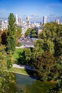 Trees and buildings in city against sky