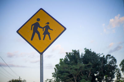 Close-up of road sign against sky