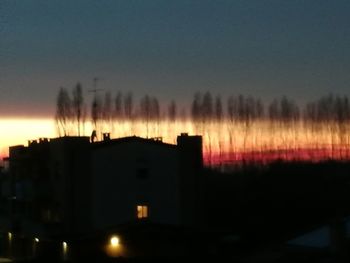 Silhouette buildings against sky during sunset