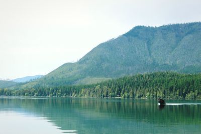 Scenic view of lake by mountains against clear sky