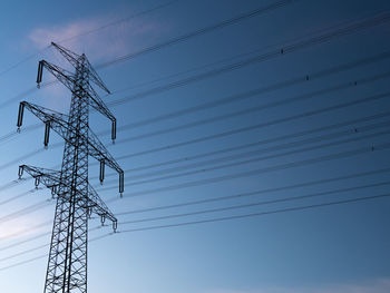 Low angle view of electricity pylon against sky