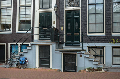 Bicycle in front of entrance doors on townhouse in amsterdam. the netherland capital full of canals.