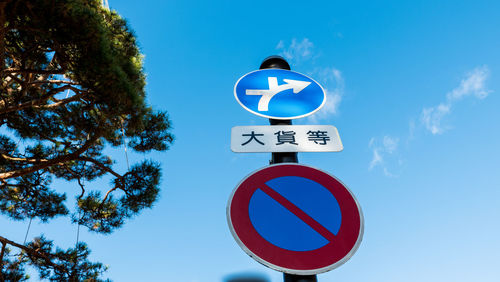 Low angle view of road sign against sky