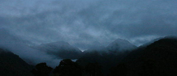Scenic view of silhouette mountains against sky at night