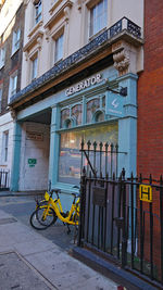 Bicycle on footpath against building in city