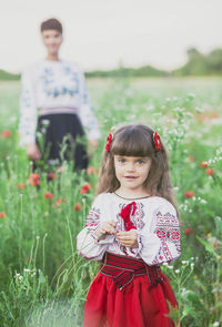 Portrait of young woman standing on field