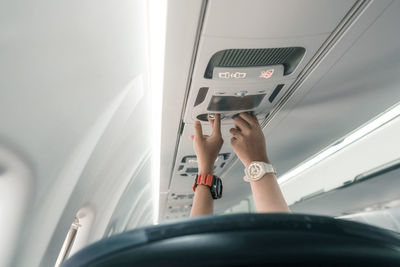 Cropped hands of men and woman in airplane