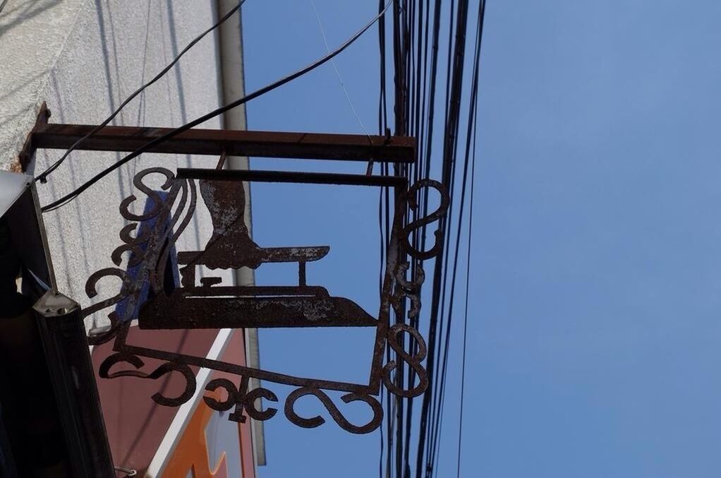 low angle view, clear sky, built structure, architecture, metal, blue, connection, sky, day, part of, metallic, outdoors, building exterior, no people, cropped, cable, sunlight, railing, copy space, directly below