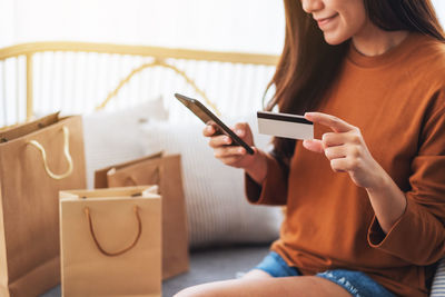 Midsection of woman using mobile phone