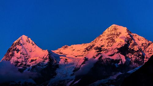 Scenic view of snowcapped mountains against clear blue sky