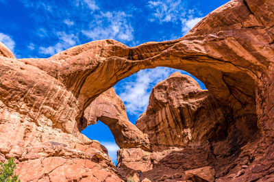 Low angle view of rock formation in desert against blue sky