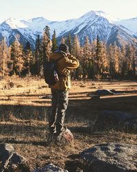 Rear view of man standing on snow covered landscape