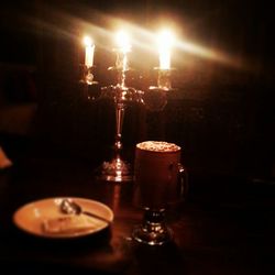 Close-up of lit candle in dark room