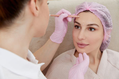 Close-up of young woman applying medicine
