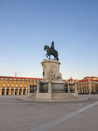 Statue in city against sky